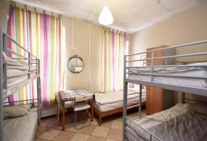 a dorm room with two bunk beds and a desk at Missis Hudson in Saint Petersburg
