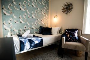 a bedroom with a bed with birds on the wall at Cannon Cottage in St John's Point