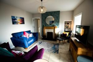 a living room with a blue couch and a fireplace at Cannon Cottage in St John's Point