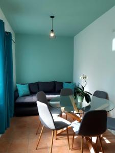 - un salon avec une table et des chaises en verre dans l'établissement SočaLand Apartmaji, à Vallée de la Soča