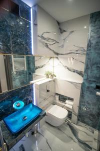 łazienka z toaletą i błękitną umywalką w obiekcie Apartament w Cieplicach 6 Gold w Jeleniej Górze