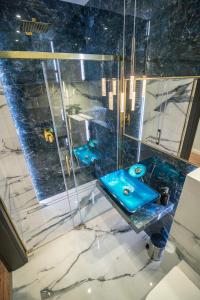 La salle de bains est pourvue d'un lavabo bleu et d'une douche. dans l'établissement Apartament w Cieplicach 6 Gold, à Jelenia Góra
