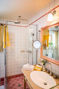 uma casa de banho com um lavatório e um chuveiro com um espelho. em Winterstellgut em Annaberg im Lammertal
