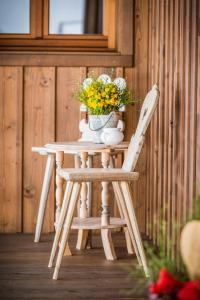 a wooden table with a vase of flowers and a chair at Winterstellgut in Annaberg im Lammertal