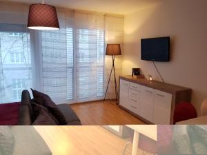 uma sala de estar com um sofá e uma televisão de ecrã plano em BullsLiving Kaisermühlen Apartment Erni next to UNO City em Viena