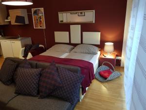 ein Schlafzimmer mit einem Bett und einem Sofa in der Unterkunft BullsLiving Kaisermühlen Apartment Erni next to UNO City in Wien