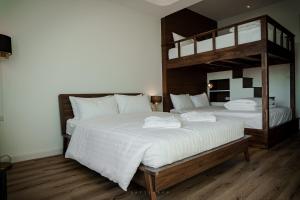 a bedroom with two bunk beds with white sheets at Play Poshtel & Cafe' in Krabi