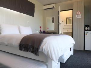 sypialnia z dużym białym łóżkiem i łazienką w obiekcie SleepOver Beitbridge w mieście Musina