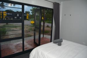 a bedroom with a bed and a large glass window at SleepOver Orpen Gate in Acornhoek