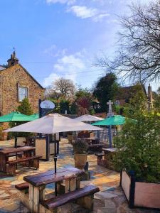 The Priory في Scorton: مجموعة طاولات نزهة مع مظلات على الفناء