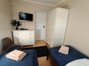 sypialnia z dwoma łóżkami, komodą i telewizorem w obiekcie Apartament Lea w Kudowie Zdrój w Kudowie Zdroju