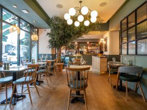 restauracja ze stołami i krzesłami oraz bar w obiekcie Mercure London Hyde Park Hotel w Londynie