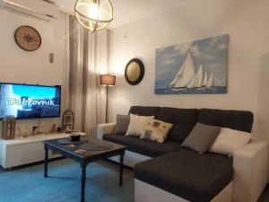 a living room with a couch and a tv at Apartment Melody in Dubrovnik