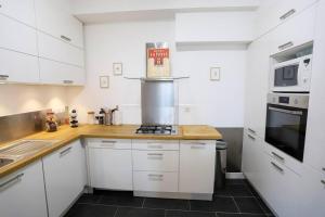 a kitchen with white cabinets and a stove top oven at Le Thiou 3 étoiles - Charmant & Authentique, Au Cœur de la Vieille Ville, Billard, 6 personnes in Annecy