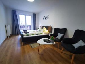 un soggiorno con divano, 2 sedie e tavolo di Pension Bergfried a Hallstatt