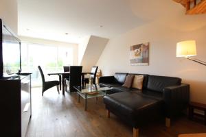 uma sala de estar com um sofá e uma mesa em Am Wintershof 5 Whg 6 em Kellenhusen