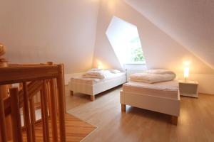 um quarto no sótão com 2 camas e uma janela em Am Wintershof 5 Whg 6 em Kellenhusen