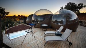 two domed spheres on a deck with a camera at MILUNA, Open Nature Rooms in Hormigos
