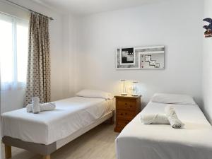 sypialnia z 2 łóżkami, komodą i oknem w obiekcie Penthouse Clavero Casasol w mieście Nerja
