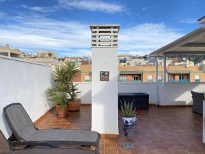balkon z krzesłem i roślinami na dachu w obiekcie Penthouse Clavero Casasol w mieście Nerja