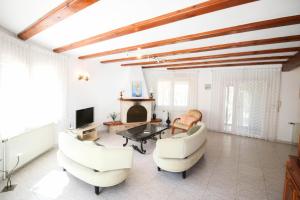 a living room with white furniture and a fireplace at La Sella PE in Pedreguer