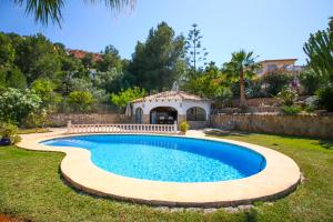a swimming pool in a yard with a gazebo at La Sella PE in Pedreguer