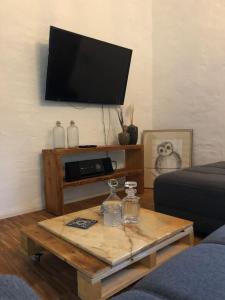 a living room with a coffee table with a flat screen tv at Lokschuppen im alten Bahnhof Industrial Style in Moschheim
