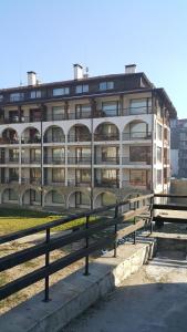 un gran edificio con una valla delante en Koko's apartments 2, en Bansko