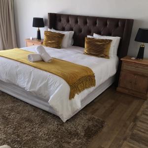 ein Schlafzimmer mit einem großen weißen Bett mit goldenen Kissen in der Unterkunft 11 On Grace in East London