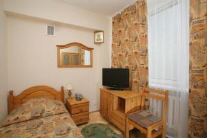 1 dormitorio con 1 cama, TV y ventana en Universitetskaya Hotel, en Moscú