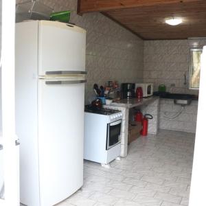 uma cozinha com um frigorífico branco e um fogão em Pousada do Carlito na Ilha do Mel