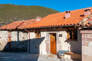 una casa con techo naranja con una colina al fondo en Terra Ecoturismo. Casa El Nido, en La Plaza