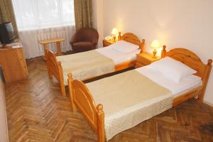 two beds in a room with two lamps at Universitetskaya Hotel in Moscow