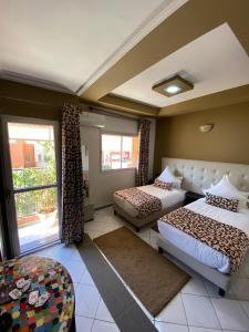 a hotel room with two beds and a window at Hotel VELSATIS in Beni Mellal