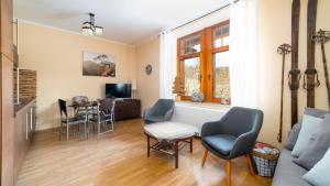 - un salon avec un canapé et une table dans l'établissement Prywatne apartamenty Sun & Snow z mini SPA, à Szklarska Poręba