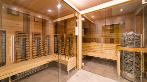 a dressing room with wooden cabinets and a glass wall at Prywatne apartamenty Sun & Snow z mini SPA in Szklarska Poręba