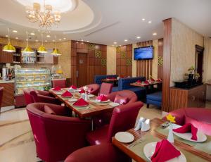 حديقة شمس للأجنحة الفندقية  في جدة: مطعم فيه كراسي حمراء وطاولات وتلفزيون