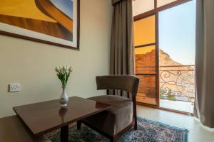 a living room with a table and a chair and a window at Al Ayjah Plaza Hotel in Sur