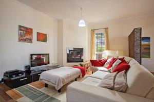 ein Wohnzimmer mit einem Sofa und einem TV in der Unterkunft Capela - Casa das Neves in Funchal