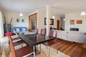 a dining room and living room with a table and chairs at Capela - Casa das Neves in Funchal