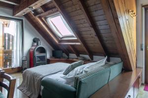 - une chambre avec un canapé vert et une fenêtre dans l'établissement Asiago Millepini - Mansarda sull'Altopiano, à Asiago