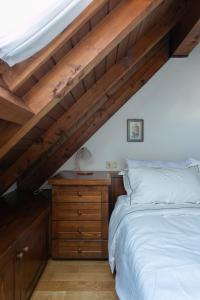 a bedroom with a bed and a wooden dresser at Asiago Millepini - Mansarda sull'Altopiano in Asiago