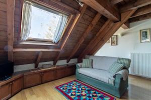 a living room with a couch and a window at Asiago Millepini - Mansarda sull'Altopiano in Asiago