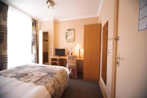 Cette chambre comprend un lit et un bureau. dans l'établissement Hotel Le Bellevue, à Saint-Hippolyte