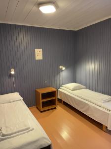 莱达尔绥里来飞亚利芬日提妲挪度酒店的一间设有两张床、一张桌子和两盏灯的房间