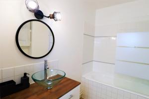 uma casa de banho com um lavatório e um espelho. em L'ECRIN Logement tout confort wifi, centre-ville, parking privé em Vannes