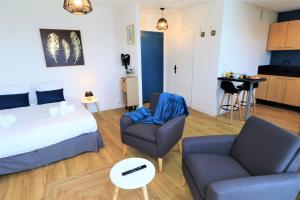 a bedroom with a bed and a couch and a table at L'ECRIN Logement tout confort wifi, centre-ville, parking privé in Vannes