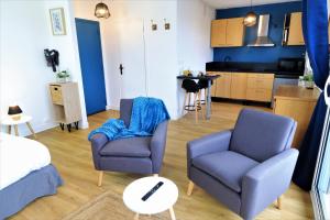 uma sala de estar com duas cadeiras e uma cozinha em L'ECRIN Logement tout confort wifi, centre-ville, parking privé em Vannes