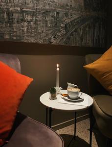 a small table with a candle and a cup of tea at LA Hotel in Lidingö