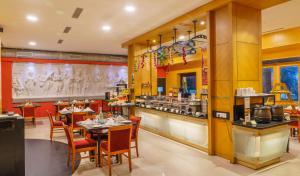 a restaurant with tables and chairs and a counter at Fortune Pandiyan Hotel, Madurai - Member ITC's Hotel Group in Madurai